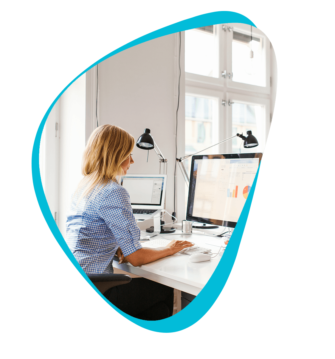 Marketing professional working at her desk. Various reports and graphs are shown on her monitor.