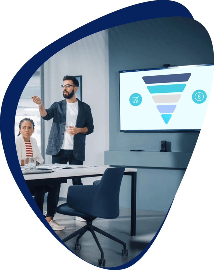 Bearded man presenting to a conference room. There's an image of a performance marketing funnel on the TV.