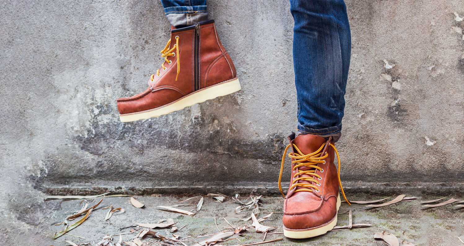 Man wearing brown leather shoes with yellow laces.